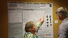 Two individuals interact in front of a poster in the poster session during lunch at the Spring 2023 SUG conference