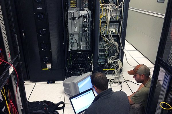 Two engineers working on a supercomputer rack at the State of Ohio Superomputer Center