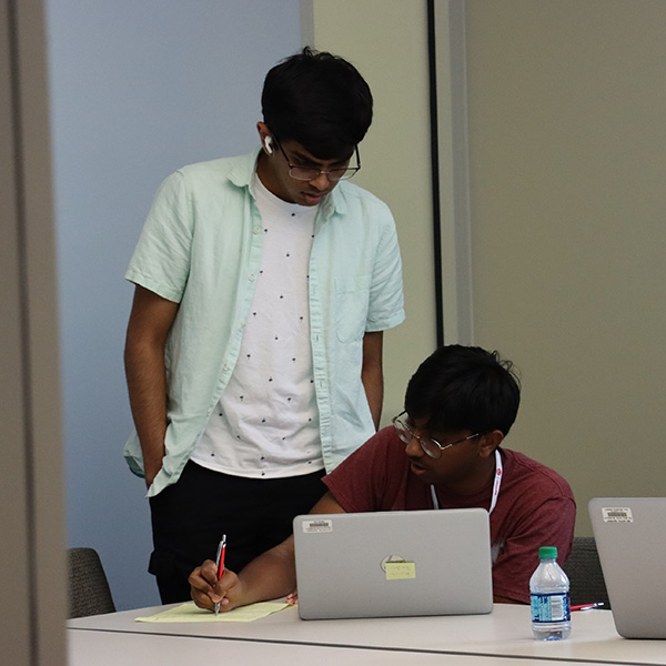 Two students working in front of a computer