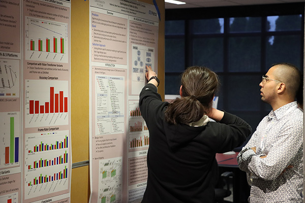 Two individuals conversing during poster presentations at 2022 ICICLE All Hands Meeting.