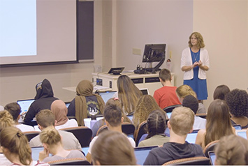 Kubatko stands in front of her classroom of students.