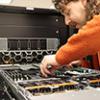 Person manipulating computer parts in a supercomputer node