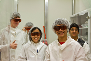Summer Institute students smiling while wearing safety chemical suits