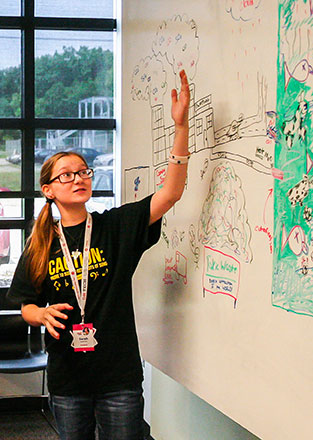 Young woman presenting from white board